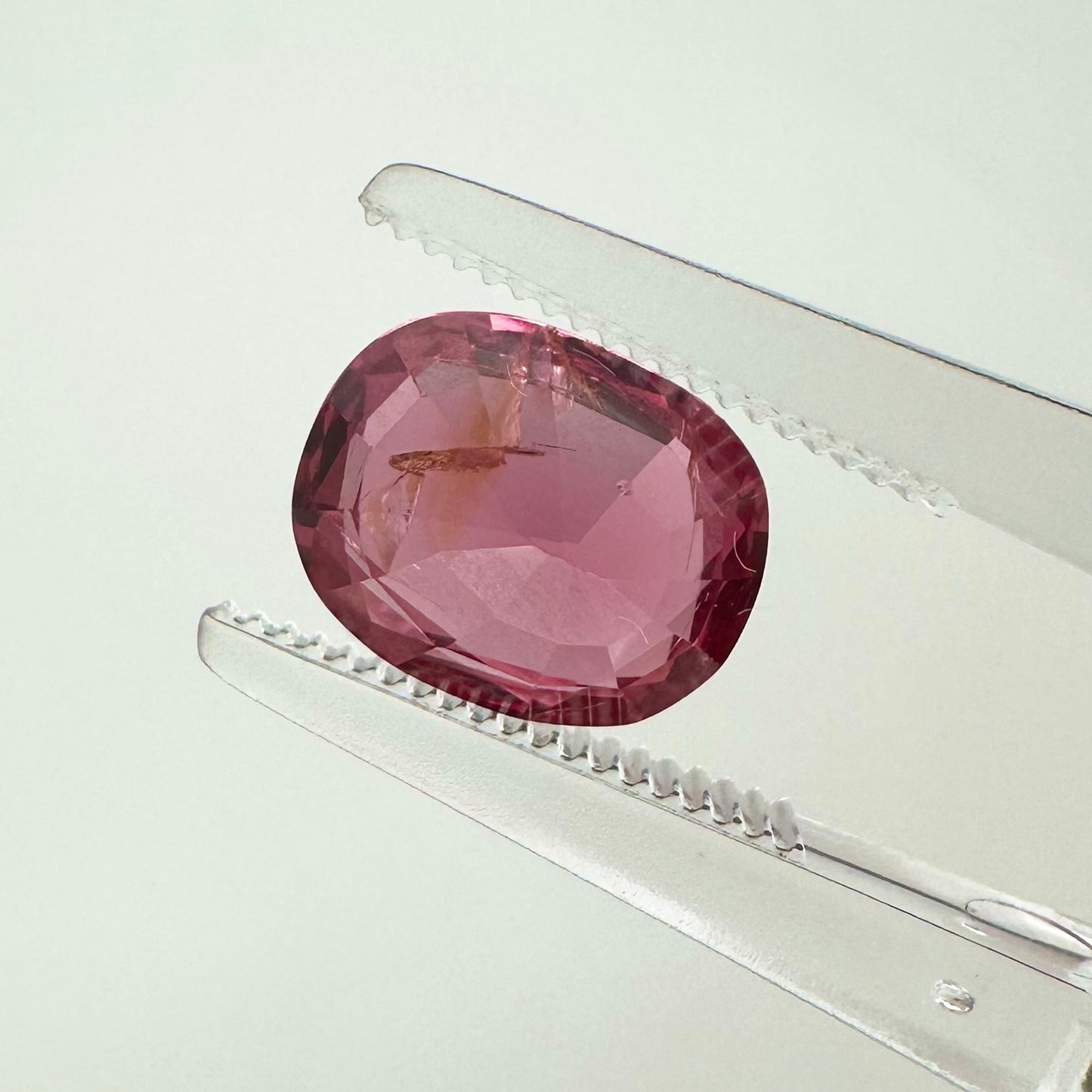 Reverse back view of the natural oval cushion electric pink orange spinel from Vietnam demonstrating its excellent clarity and lack of treatment