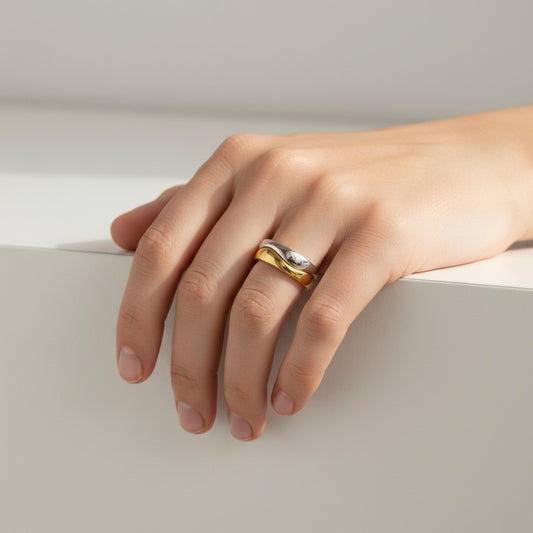 Bague Cartier Nouvelle Vague en or blanc et jaune 18k portée sur le doigt, proposée par Antique Jewelry Finds.