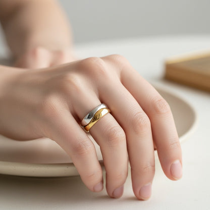 Bague Cartier Nouvelle Vague en or blanc et jaune 18k entrelacé portée sur la main par Antique Jewelry Finds