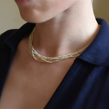 Macro shot focusing on the back of the neck, showcasing the three old-cut diamonds sparkling on the gold clasp while worn.