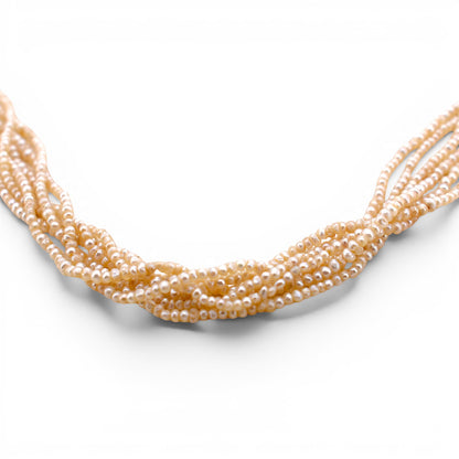 Close-up shot showing the lustrous cream orient and delicate texture of the six strands of antique pearls.