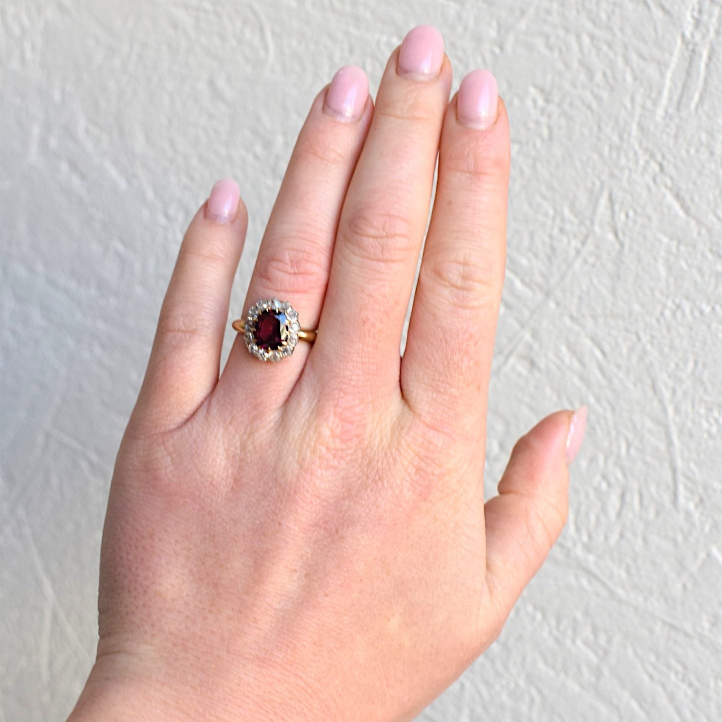 Authentic antique rubellite garnet halo ring worn on a hand for scale and appearance
