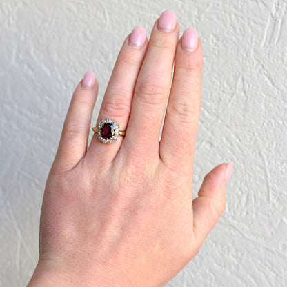 Authentic antique rubellite garnet halo ring worn on a hand for scale and appearance