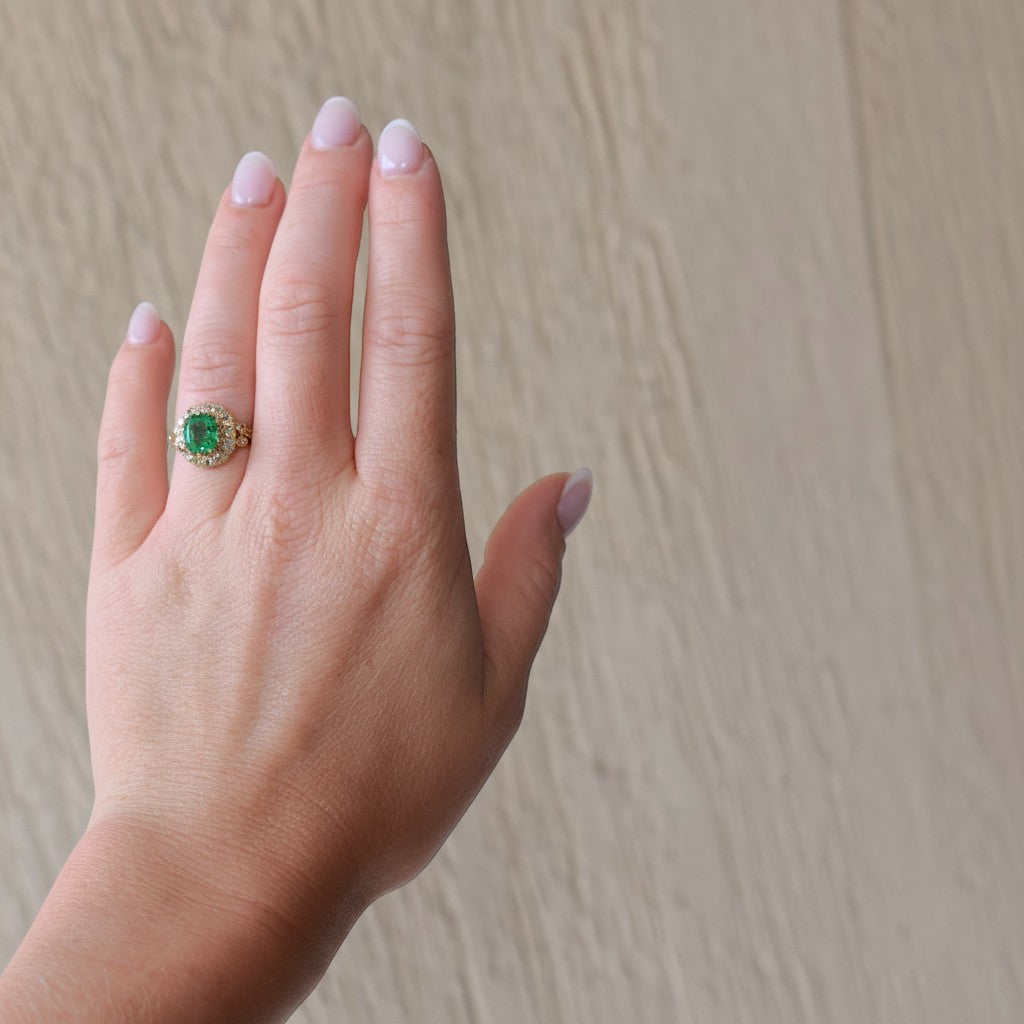 Antique French Victorian 18k gold statement ring with emerald and diamond halo, elegantly worn on a hand, size 6.5 US.