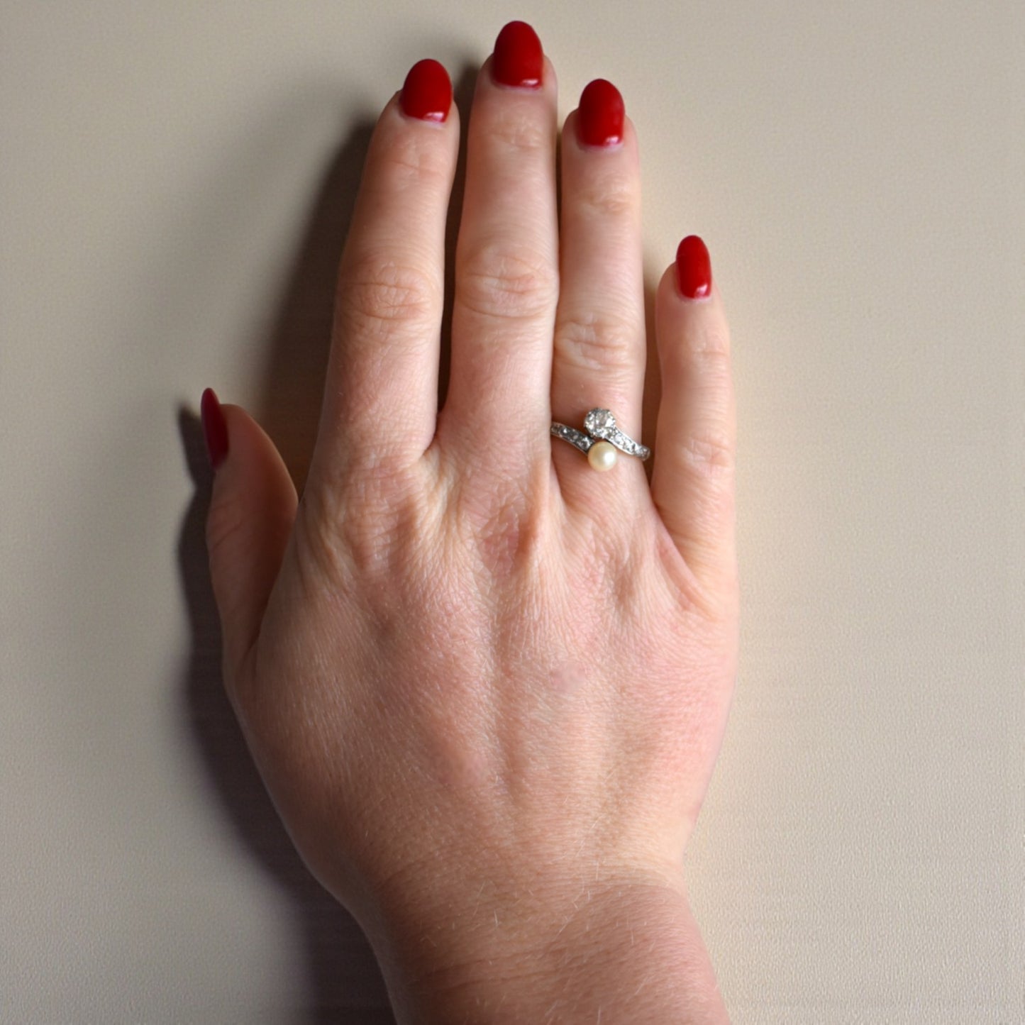 Antique pearl and diamond Toi et Moi ring worn on a hand for scale