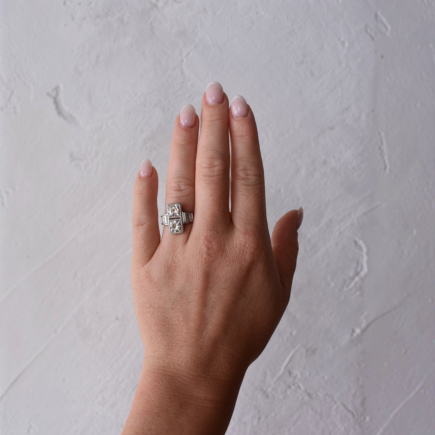 Antique French Art Deco platinum vertical Toi et Moi diamond ring elegantly worn on a hand, size 6.75 US.