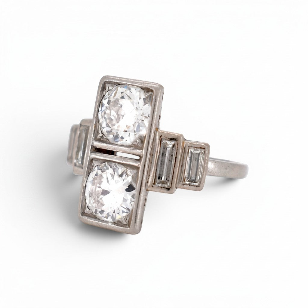 Close-up view of the geometric step-cut baguette diamonds flanking the shoulders of the platinum Art Deco ring.