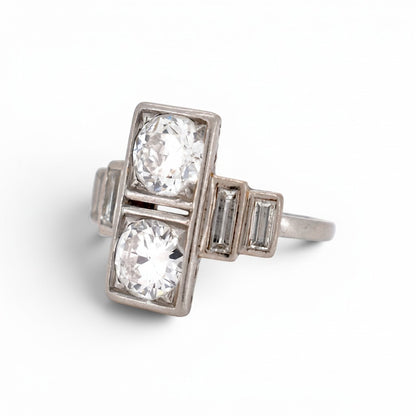 Close-up view of the geometric step-cut baguette diamonds flanking the shoulders of the platinum Art Deco ring.