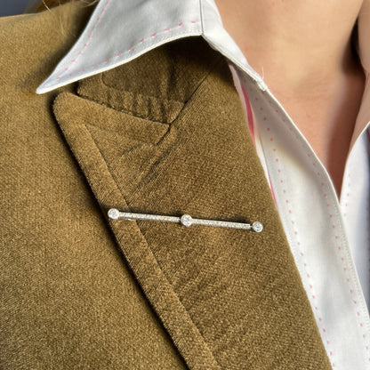 Art Deco diamond bar brooch worn on a black lapel for scale and contrast