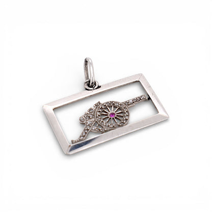 Detailed macro view of the platinum openwork cannon showing the fine diamond pavé and the central red ruby.