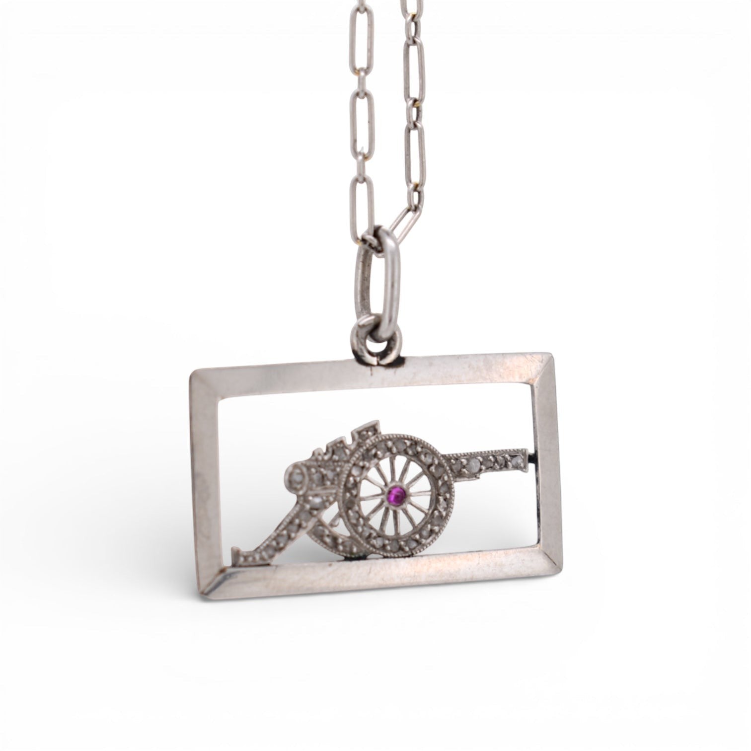 Close-up shot focusing on the vibrant natural red ruby accentuating the wheel of the antique platinum military cannon.