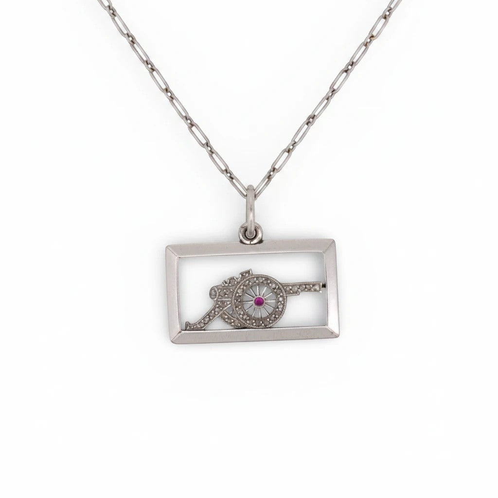 Antique 1920 Art Deco solid platinum rectangular pendant featuring a diamond military cannon with a ruby wheel center by Antique Jewelry Finds.