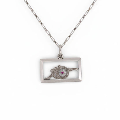 Antique 1920 Art Deco solid platinum rectangular pendant featuring a diamond military cannon with a ruby wheel center by Antique Jewelry Finds.