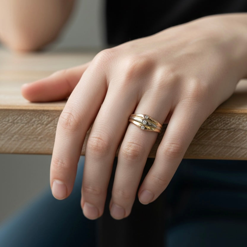Cartier 3-tone gold diamond ring worn on a hand for scale and style