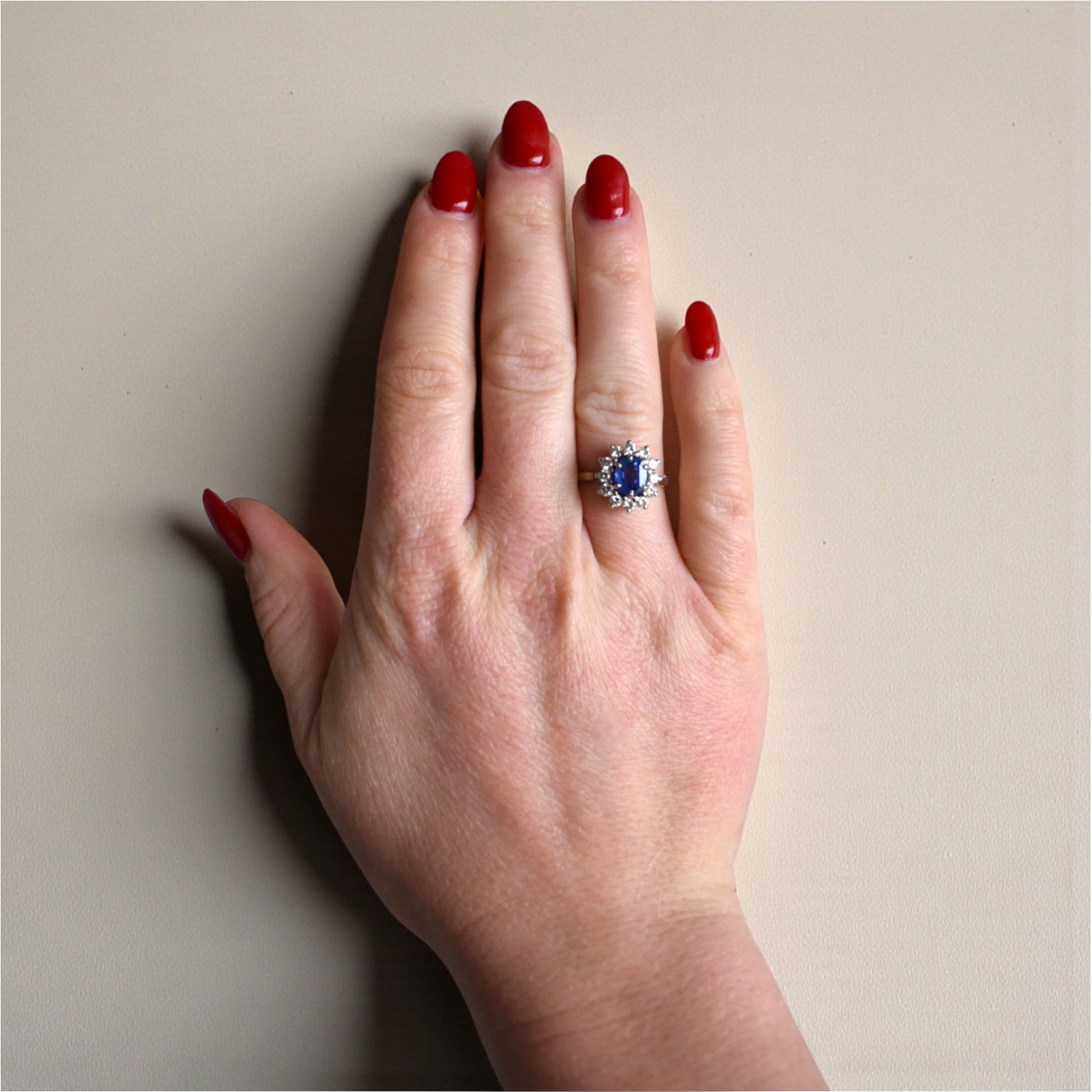 Certified Ceylon sapphire and diamond halo engagement ring worn on a hand for scale