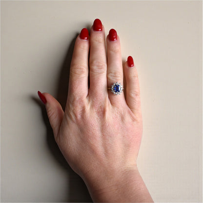 Certified Ceylon sapphire and diamond halo engagement ring worn on a hand for scale