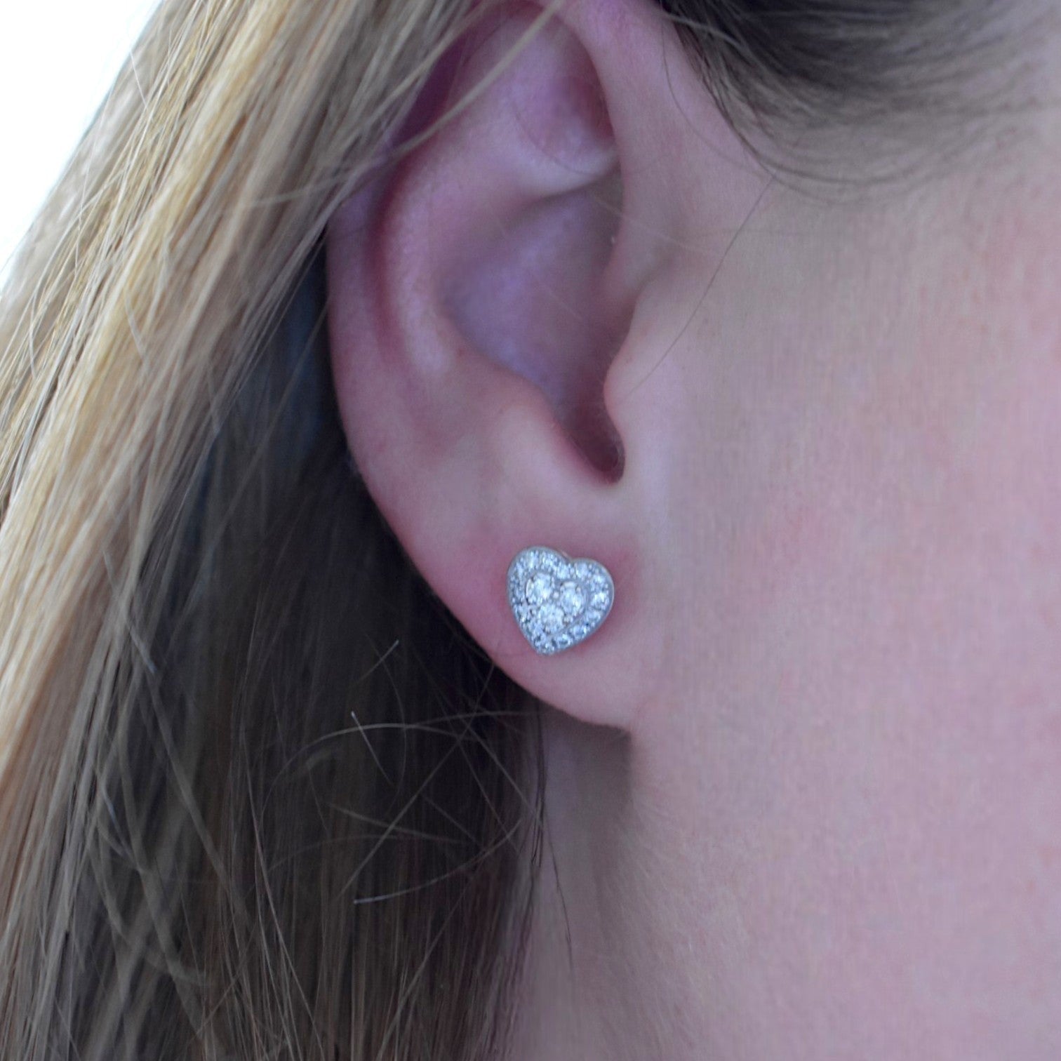 Chopard inspired diamond heart earrings worn on an ear for scale and sparkle