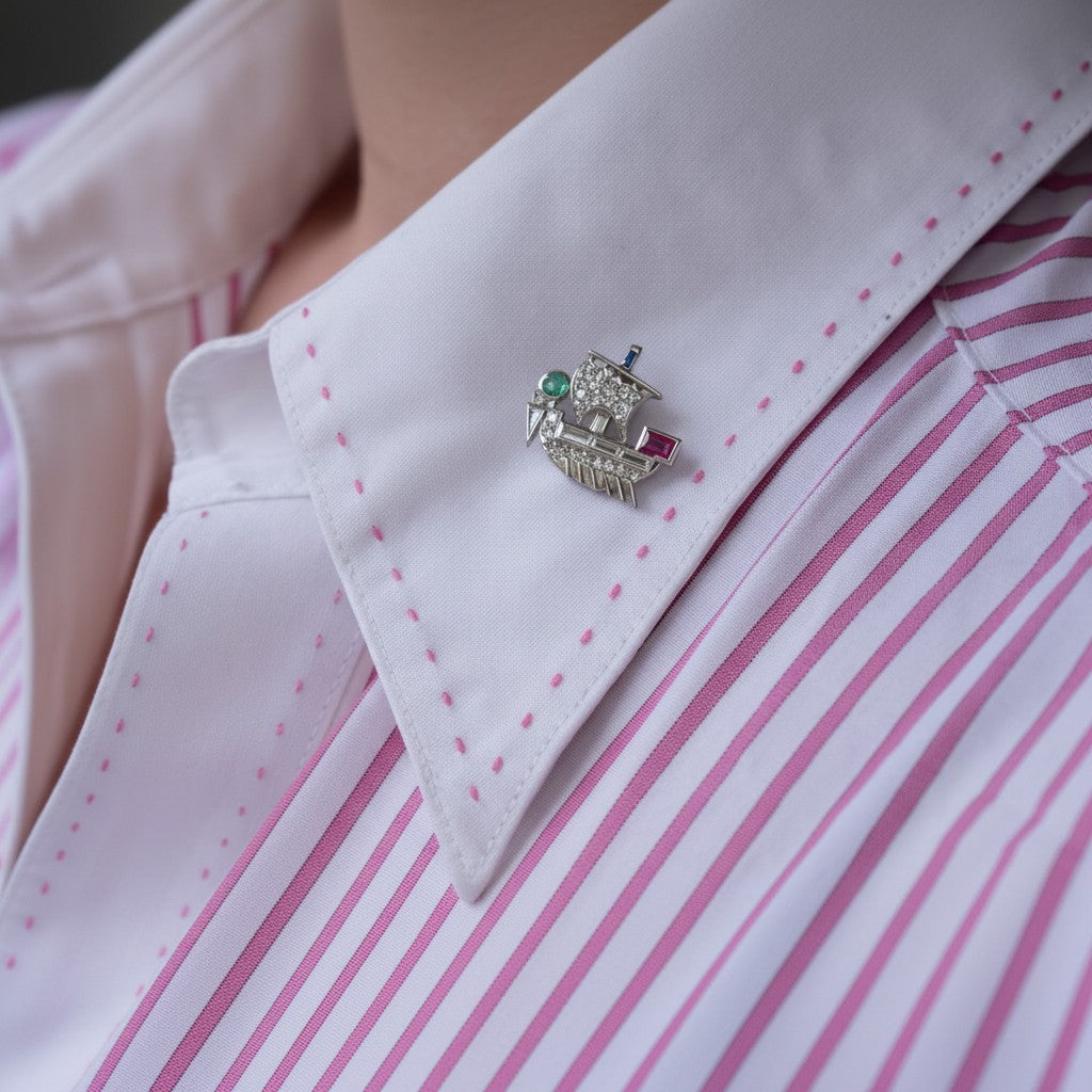 Extreme close-up shot of the multi-gemstone Viking ship pin styled on a tie, highlighting its historic scale, color contrast, and sparkle against dark fabric.