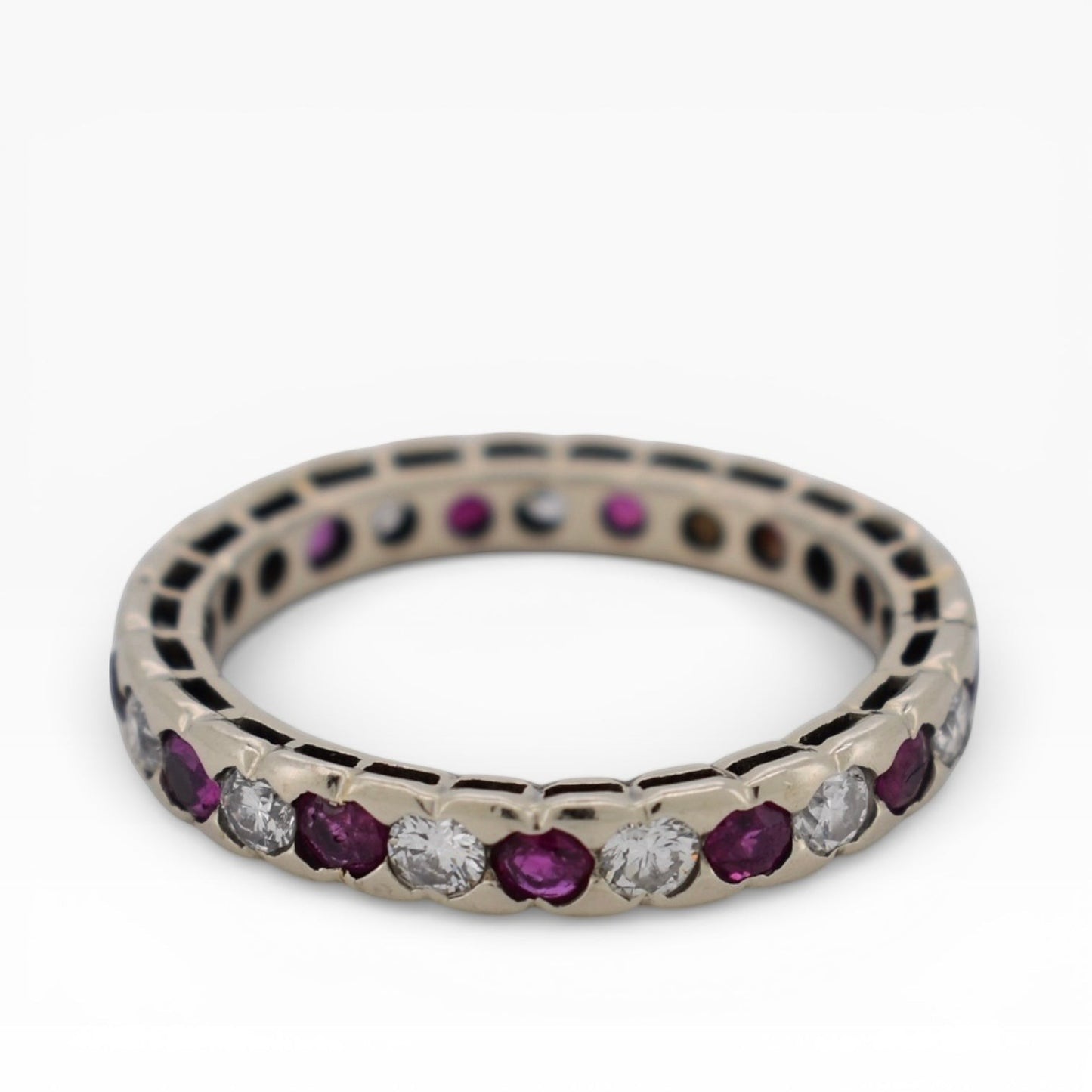 Top-down view showing the continuous gemstone loop of a full ruby diamond eternity band