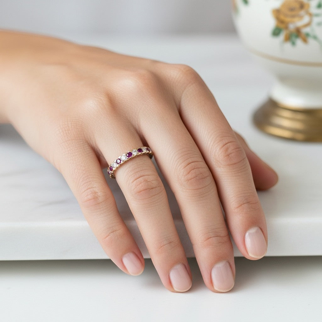 Vintage ruby and diamond eternity ring worn on a finger as a stackable wedding band
