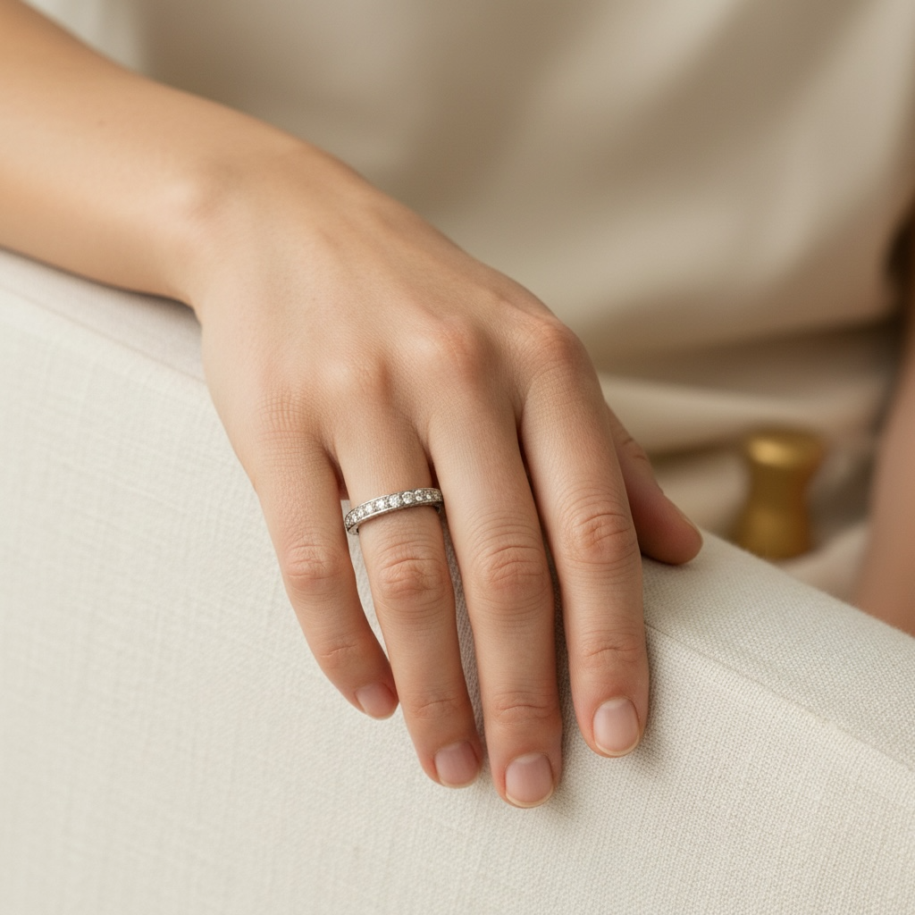 Antique Art Deco platinum diamond eternity band worn on a hand, paired with an engagement ring