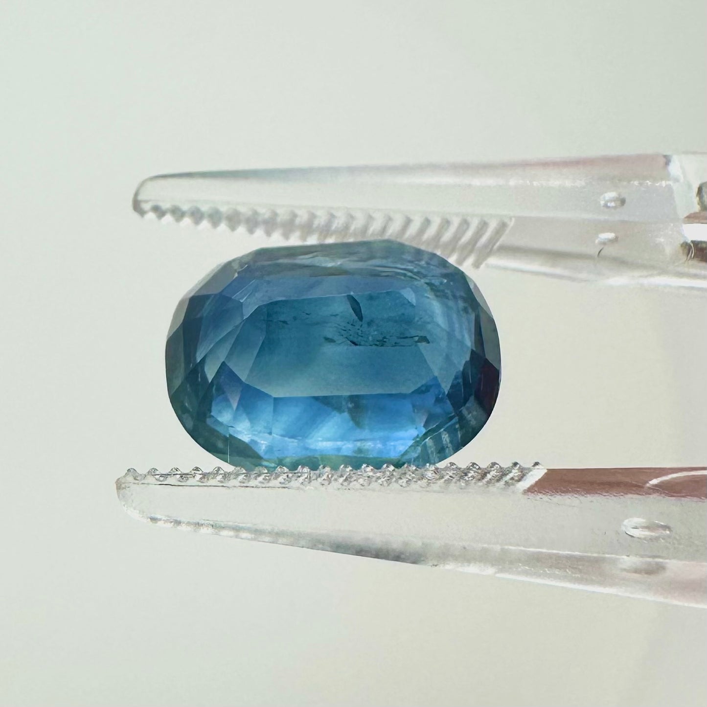 Side profile view of the heated 3.62 carat blue oval cushion sapphire highlighting its excellent symmetry and pavilion depth.
