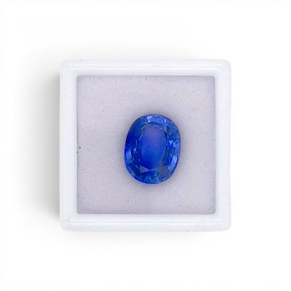 Loose 5.67 carat natural oval cushion cut blue sapphire gemstone from Ceylon (Sri Lanka) displayed inside a luxury presentation gem box by Antique Jewelry Finds.