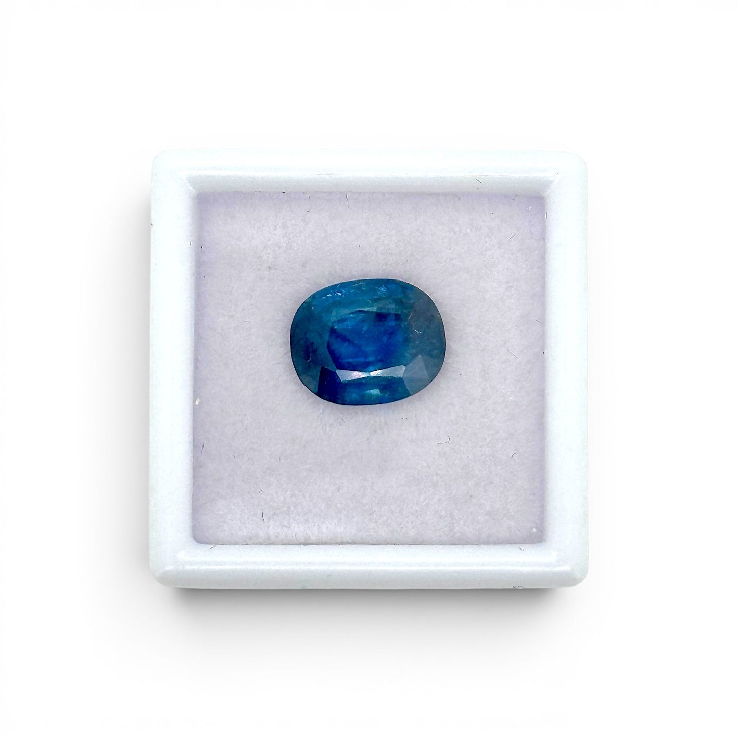 Loose 3.62 carat natural oval cushion cut blue sapphire gemstone displayed inside a luxury presentation gem box by Antique Jewelry Finds.
