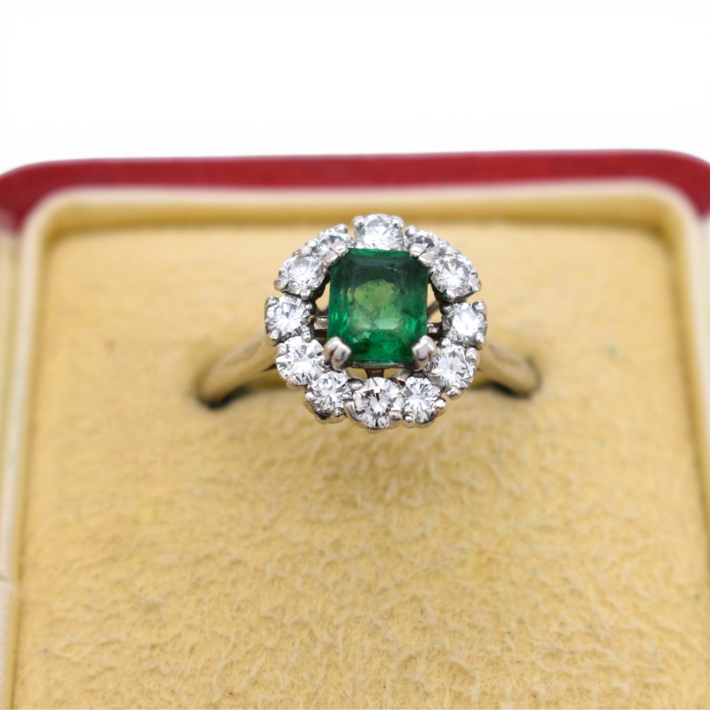 Close-up of 1 carat natural emerald surrounded by 12 brilliant cut diamonds