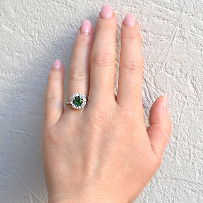 Signed Mellerio emerald and D-VVS diamond ring worn on a hand for scale