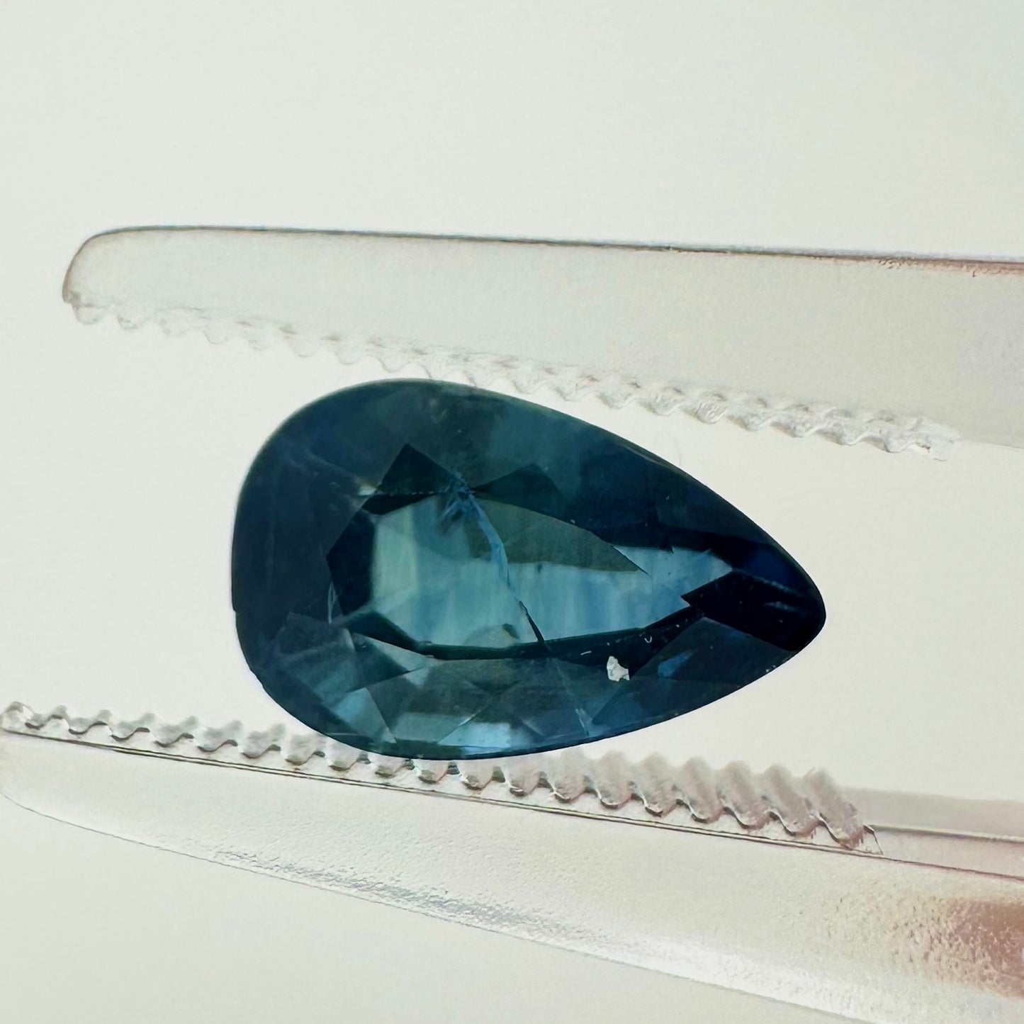 Extreme macro face shot of the 1.40ct natural blue sapphire showcasing its elegant pear shape, brilliant teardrop proportions, and rich color.