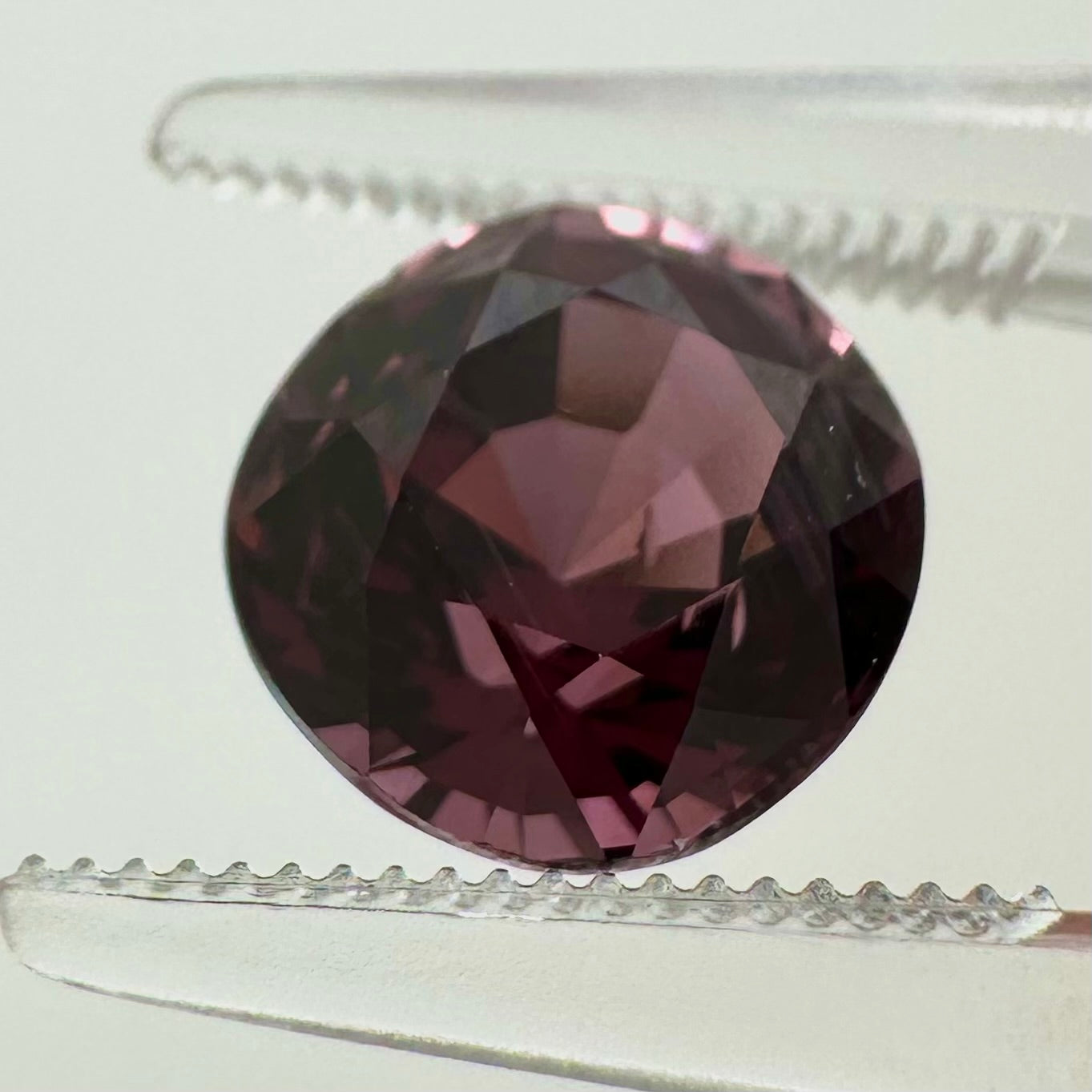 Extreme macro face shot of the 3.20ct natural deep pink spinel showcasing its exceptional oval cushion cut and crisp facets.