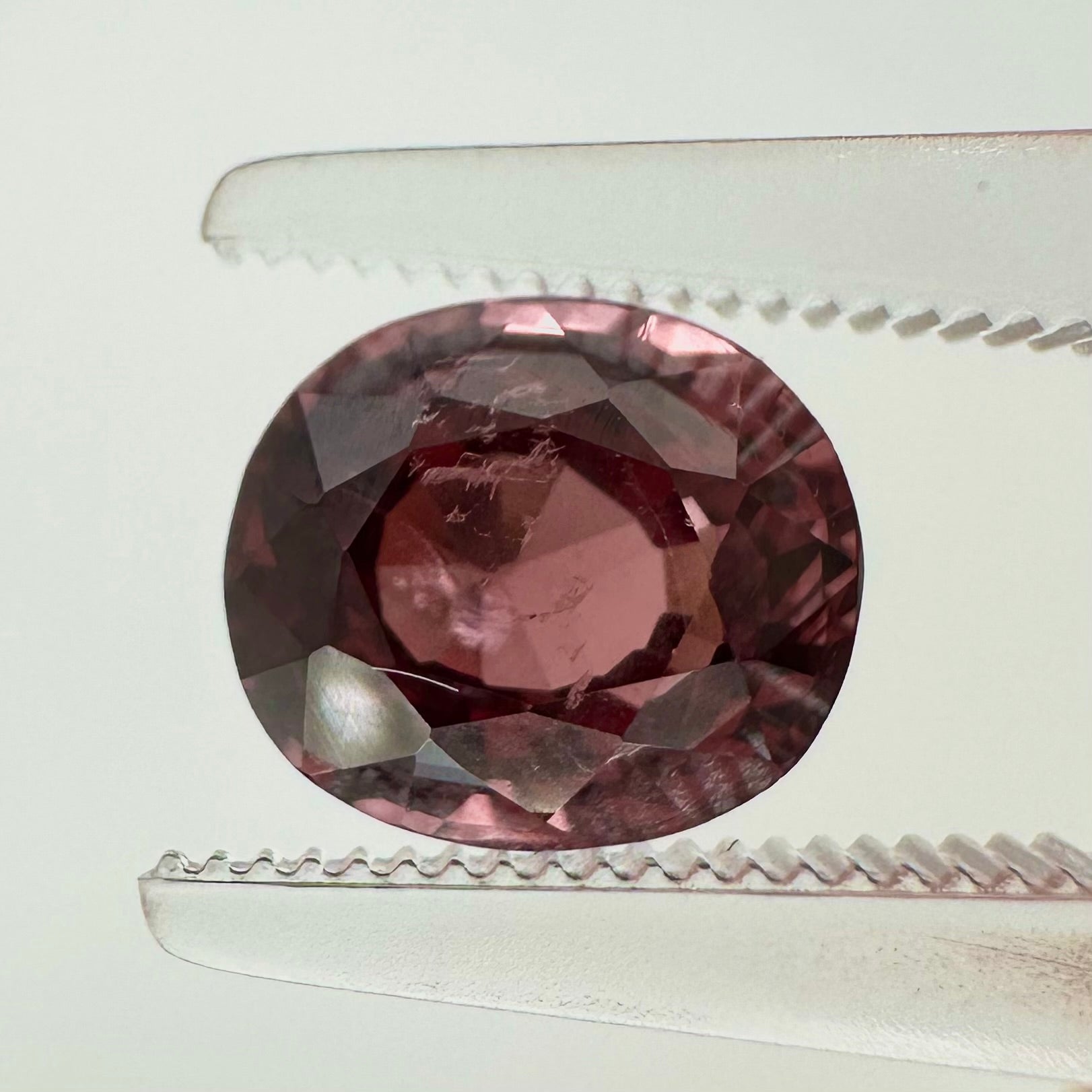 Extreme macro face shot of the 2.30ct natural deep pink spinel showcasing its exceptional oval cushion cut and crisp facets.