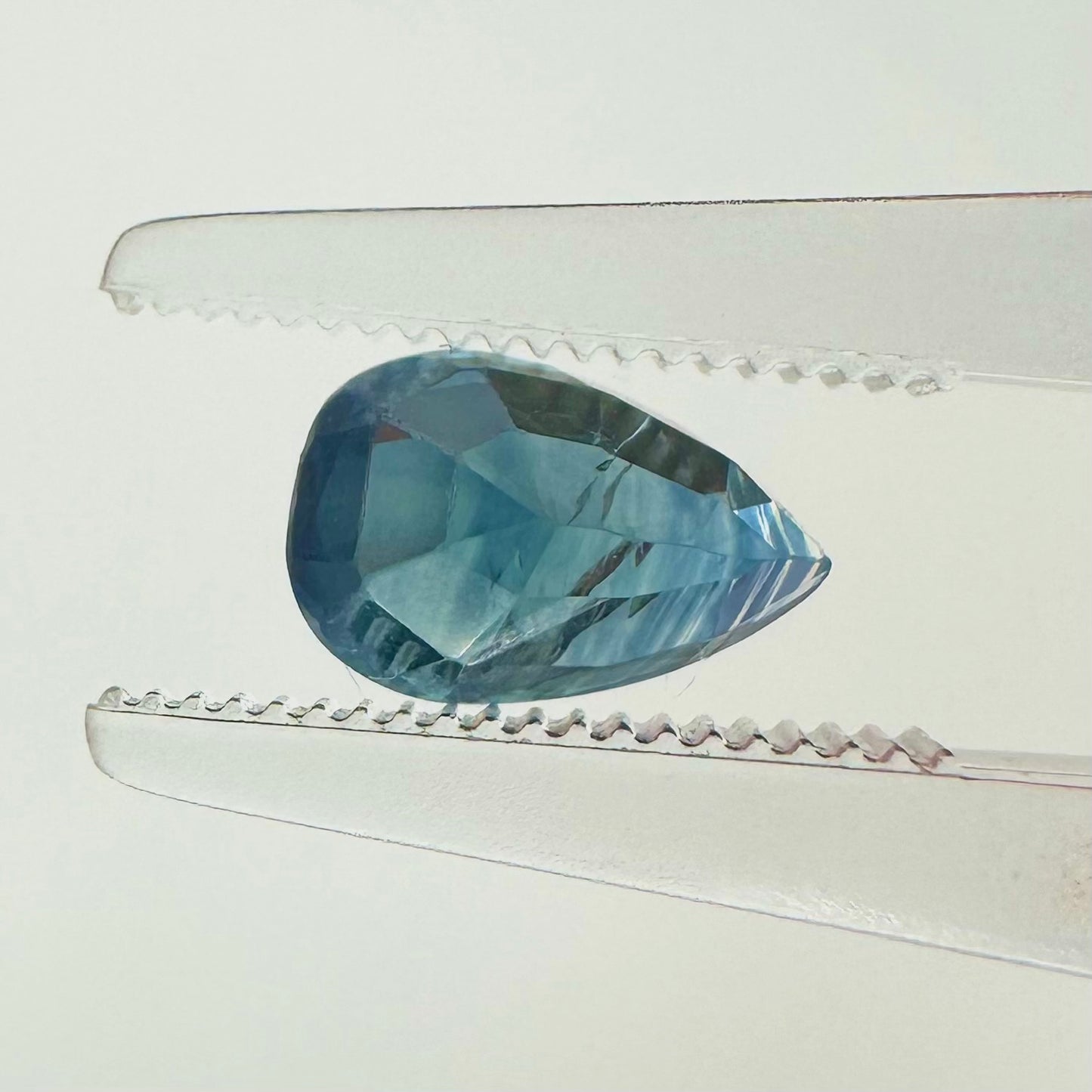 Reverse back view of the natural pear-shaped blue sapphire demonstrating its beautiful clarity, clean faceting, and fine luster.