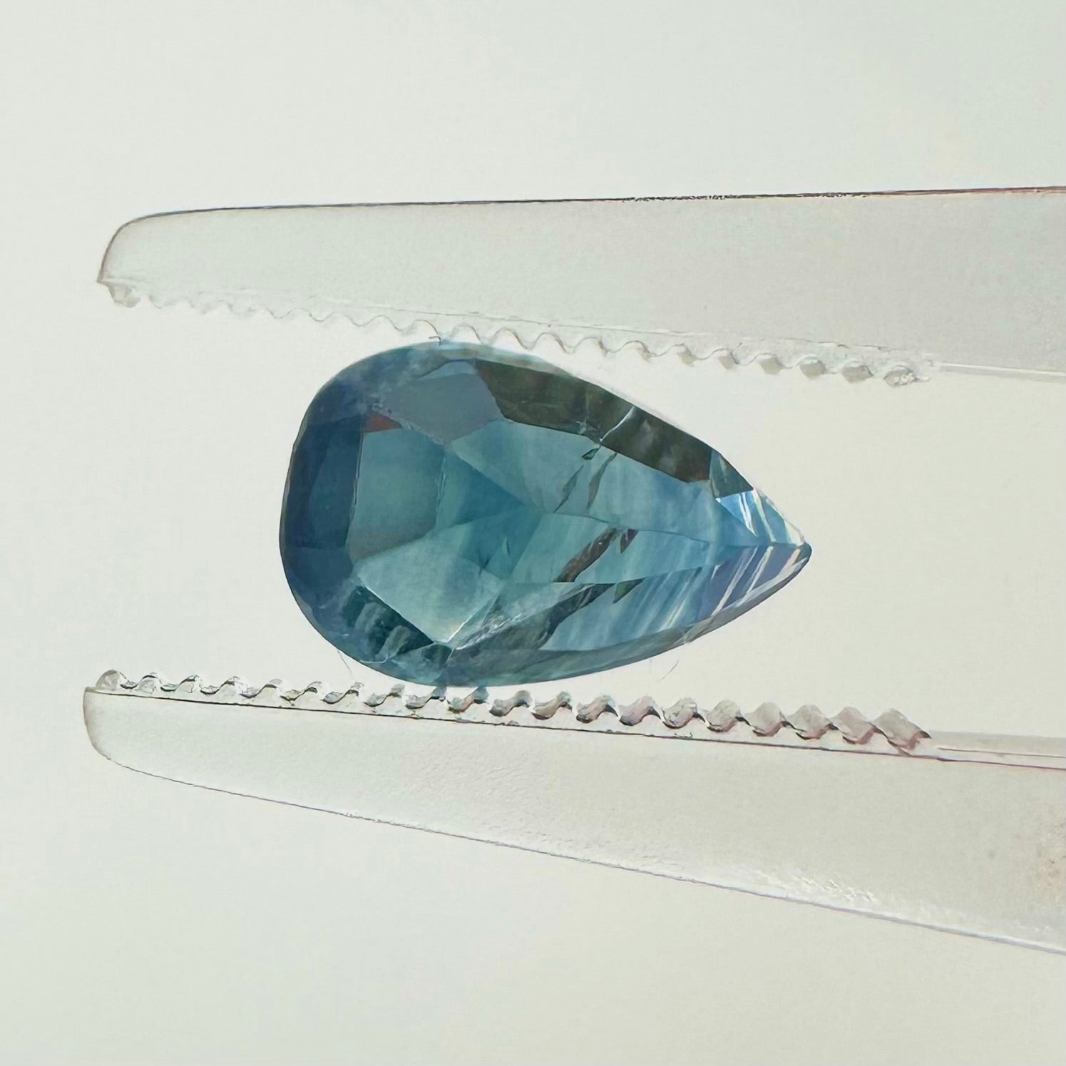 Reverse back view of the natural pear-shaped blue sapphire demonstrating its beautiful clarity, clean faceting, and fine luster.