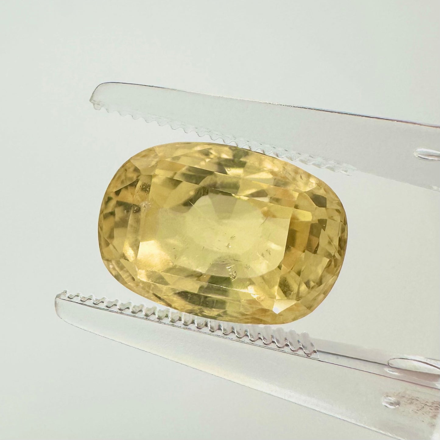 Extreme macro face shot of the 6.10ct natural yellow Ceylon sapphire showcasing its magnificent oval cushion cut and vibrant golden brilliance.