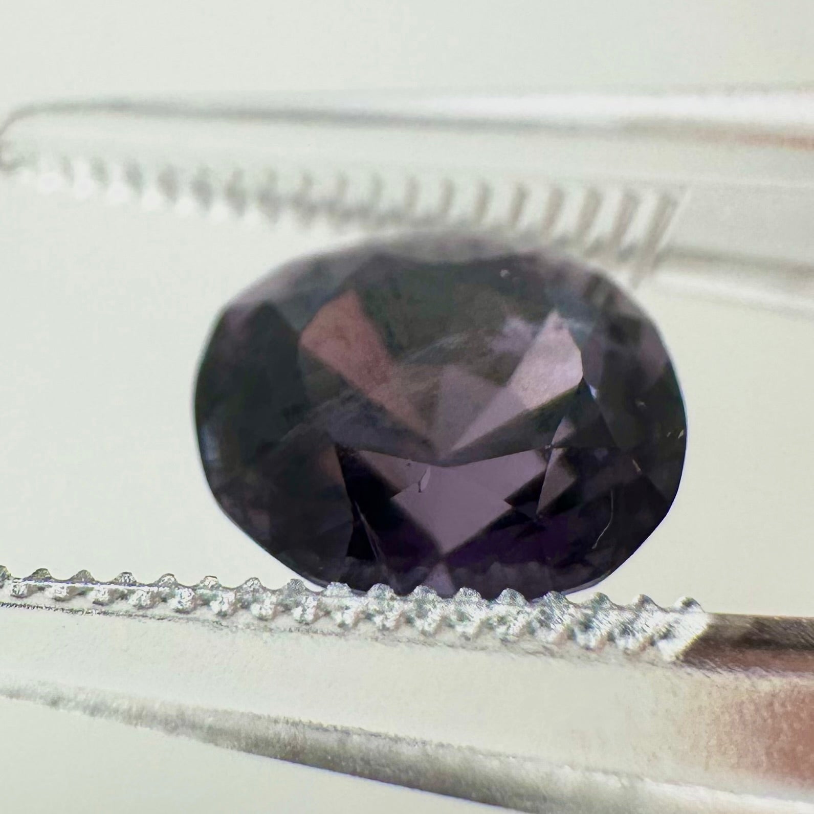 Side profile view of the unheated oval cushion purple spinel gemstone highlighting its perfect pavilion depth and symmetry.