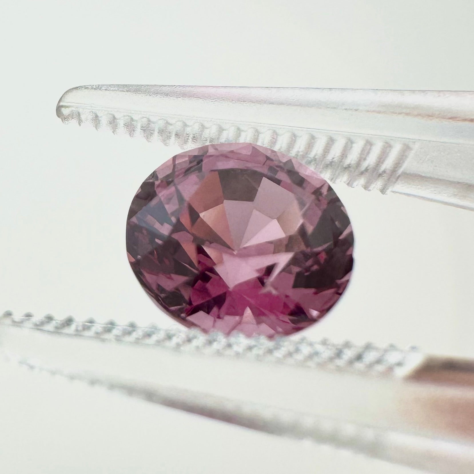 Side profile view of the unheated 1.75 carat Vietnam vivid pink spinel highlighting its perfect round symmetry and pavilion depth.