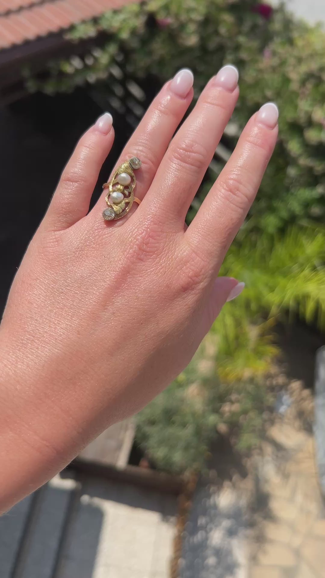 High-definition video capturing the soft iridescent glow of the natural pearls, the fiery brilliance of the 0.80-carat old-cut diamonds, and the fluid, organic lines of the circa 1910 Antique Art Nouveau 18k gold ring in motion.