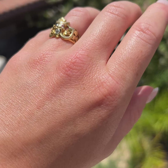 High-definition video capturing the intricate, sculptural details of the 18k gold gargoyle, the sharp red glint of the ruby eyes, and the fiery flash of the diamond in its mouth on the circa 1910 Antique Art Nouveau ring in motion.