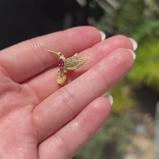 High-definition video capturing the exquisite craftsmanship, fiery diamond brilliance, and rich ruby accents of the vintage E. Wolfe & Co signed and numbered 18k gold hummingbird brooch in motion.