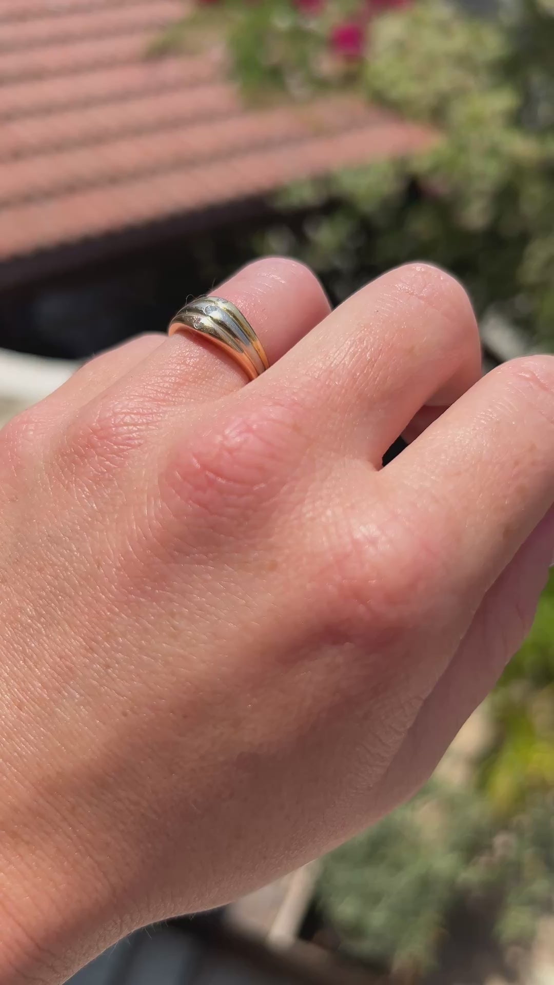 High-definition video capturing the iconic intertwined bands of the 18k three-tone gold Trinity style ring, the sharp fiery brilliance of the 3 diamonds, and the authentic engraved signature and serial number on the shifting polished surfaces in motion.