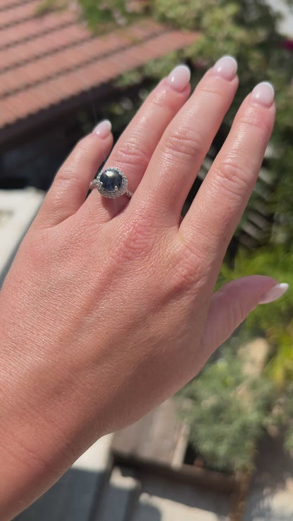 High-definition video capturing the deep blue flashes of the sapphire, the fiery brilliance of the surrounding diamond halo, and the modern polished luster of the circa 2000 contemporary 18k gold ring in motion.