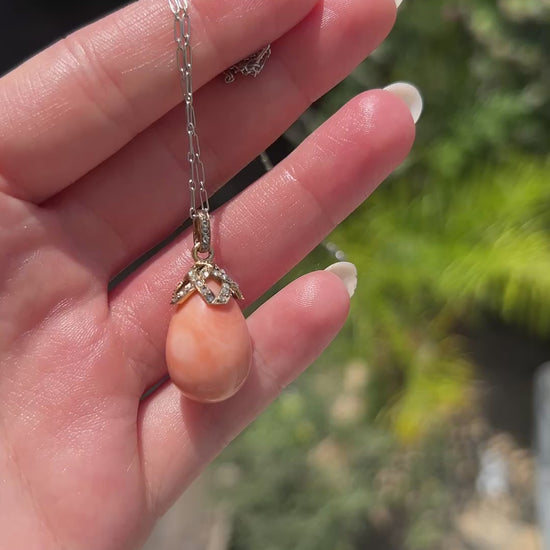 High-definition video capturing the soft, warm luster of the natural pink-orange coral drop, the fiery brilliance of the antique diamonds, and the rich, detailed 18k gold craftsmanship of the circa 1900 Victorian pendant in motion.