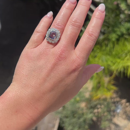 High-definition video capturing the velvety blue flashes of the certified 4-carat unheated Ceylon sapphire, the fiery brilliance of the surrounding diamond cluster halo, and the geometric elegance of the Art Deco platinum setting in motion.