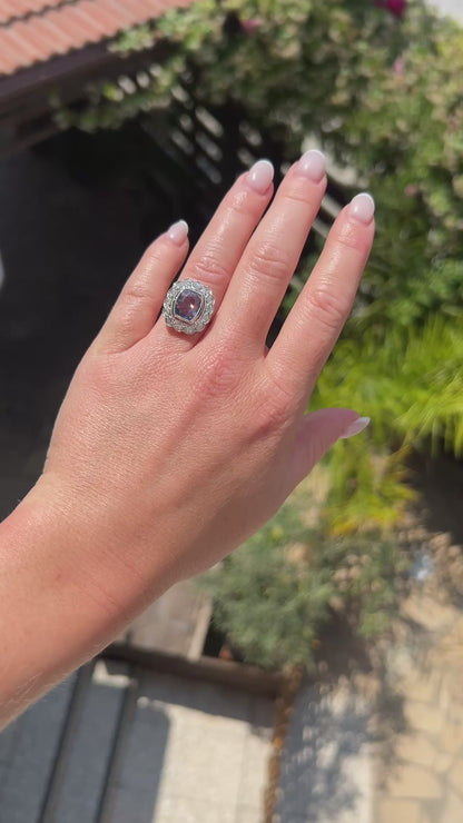 High-definition video capturing the velvety blue flashes of the certified 4-carat unheated Ceylon sapphire, the fiery brilliance of the surrounding diamond cluster halo, and the geometric elegance of the Art Deco platinum setting in motion.