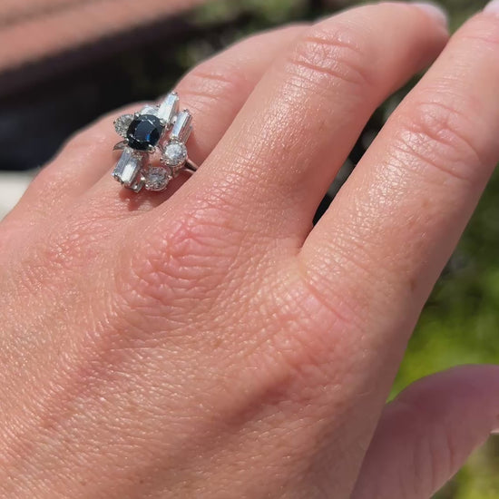 High-definition video capturing the striking contrast, lively sapphire blue flashes, and fiery diamond sparkle of the vintage Modernist 18k white gold ring in motion.