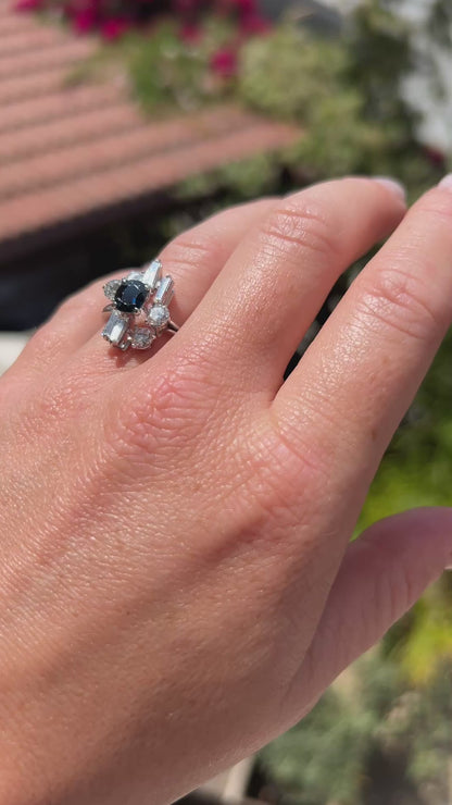 High-definition video capturing the striking contrast, lively sapphire blue flashes, and fiery diamond sparkle of the vintage Modernist 18k white gold ring in motion.