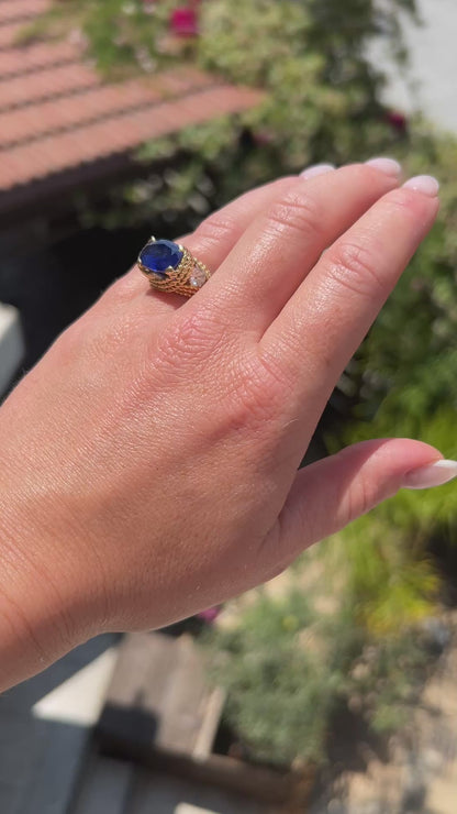 High-definition video capturing the velvety blue flashes of the 5.20ct unheated Ceylon sapphire, the fiery diamond sparkle, and the rich texture of the braided 18k gold Mid-Century ring in motion.