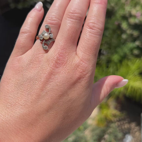 High-definition video capturing the soft iridescent glow of the antique pearl, the fiery brilliance of the old-cut diamonds, and the fluid, organic curves of the 1910 Art Nouveau 18k gold and platinum ring in motion.